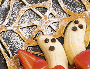 Cobweb Pancakes with banana spooks and strawberry sauce