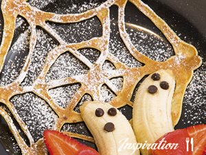 Cobweb Pancakes with banana spooks and strawberry sauce